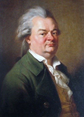 Daniel Schubart in einem gr&uuml;nen Jackett, gelber Weste und wei&szlig;en R&uuml;schenhemd vor braunem Hintergrund